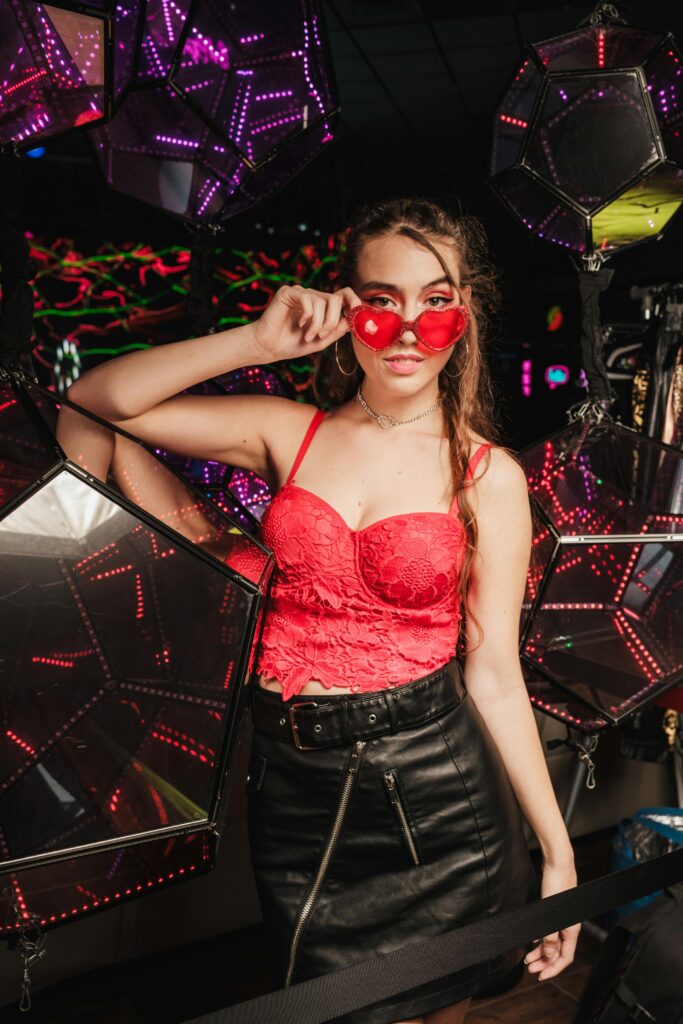 fille chic en discothèque portant jupe cuir courte et top rouge en dentelle